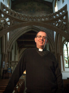 Photo of the Rev Richard Coles standing in a church